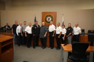 Retiring Cicero Police Chief Jerry Chlada Jr., poses with Town President Larry Dominick and members of the board and Cicero Police Department