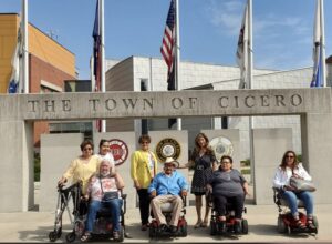 Senior Director Diana DOminick and Trustee Blanca Vargas present motorized wheel chairs to several seniors who needed mobility assistance