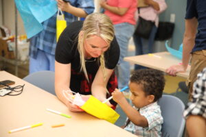 Special Events Director Patti Salerno helps one of the children create art for his mother at the annual Mother and Son Dance held Friday May 10, 2024 at the Cicero Community Center.